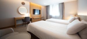 Postel nebo postele na pokoji v ubytování Ulsan City Hotel