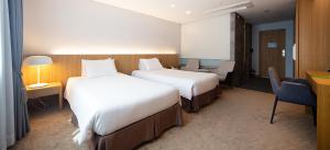 Postel nebo postele na pokoji v ubytování Ulsan City Hotel