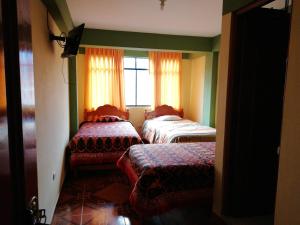 a room with two beds and a window at Scheler Artizon Trek`s House in Huaraz