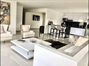 una sala de estar blanca con mesa y sillas en Villa Nova Condominio, en La Plata