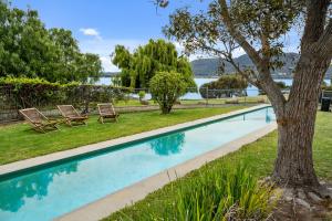 basen z 2 krzesłami i drzewem w obiekcie Riverfront Motel & Villas w mieście Hobart