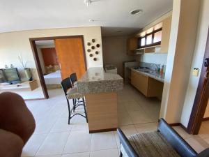 Il comprend une cuisine et un salon avec une table et des chaises. dans l'établissement Beach Kariri Residence Privado, à Cumbuco