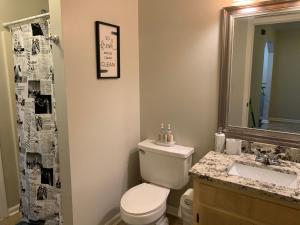 a bathroom with a toilet and a sink and a mirror at Entire - Beautiful townhouse in Tally near everything! in Tallahassee