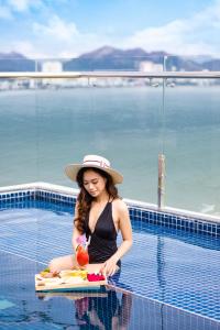 a woman in a hat sitting in a swimming pool at Imperial Nha Trang in Nha Trang +102 photos