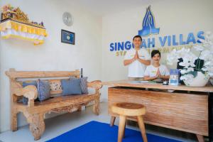 a man and a woman standing in a room with a table at Singgah Villas Seminyak in Seminyak