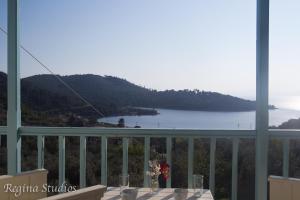 a balcony with a table and a view of a lake at Skalopati Studios & Villa in Panormos Skopelos
