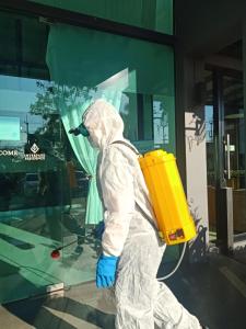 a person in a white suit walking in front of a building at Interpark Hotel & Residence, Eastern Seaboard Rayong in Ban Phan Sadet Nok