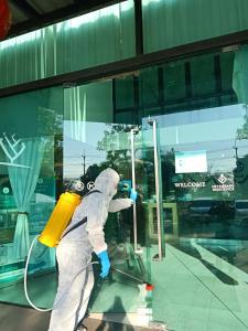 a person in a white suit washing a window at Interpark Hotel & Residence, Eastern Seaboard Rayong in Ban Phan Sadet Nok