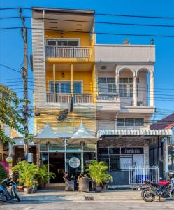 een geel gebouw met een balkon in een straat bij Lemon Loft Boutique Room in Hua Hin