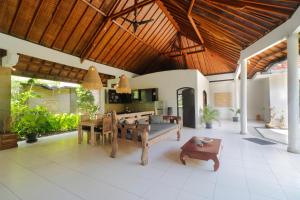 塞米亚克Singgah Villas Seminyak的带木质天花板和桌子的客厅