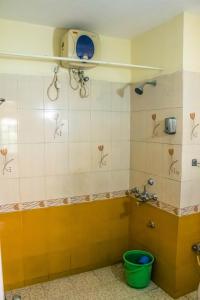 La salle de bains est pourvue d'une douche et d'un seau. dans l'établissement Utopia Holiday Candolim, à Candolim