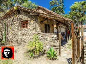 uma pequena casa de pedra com um sinal em frente em Casa del Telegrafista em La Higuera