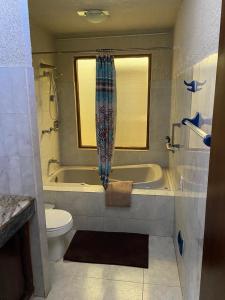 a bathroom with a tub and a toilet and a sink at casa lomas de mazatlan in Mazatlán