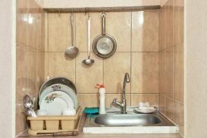 a kitchen counter with a sink and utensils at Уютная смарт-квартира возле областной лечебницы, моря и Куяльника in Odesa