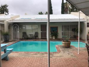 a swimming pool in front of a house at Kliprand Guest House in Springbok
