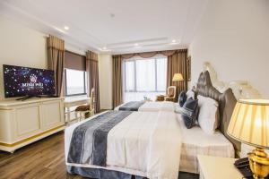 ein Schlafzimmer mit einem großen Bett und einem TV in der Unterkunft Khách sạn Minh Phú Diamond Palace in Diễn Châu
