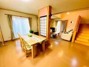 uma sala de estar com uma mesa e um sofá em Ecco's House エッコズハウス em Shiraoi