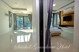 a bedroom with a door open to a room with a bed at Saichon Grand View in Ban Lam Rua Taek