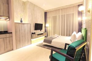 a hotel room with a bed and a television at Menteng Park Exclusive Emerald in Jakarta