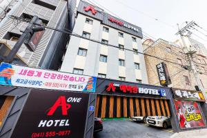 a hotel with signs in front of a building at Cheonan A One Hotel in Cheonan