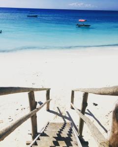 una valla de madera en una playa con el océano en Vanilla en Nungwi