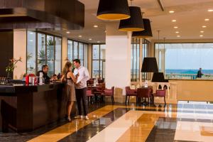 a man and woman standing at a bar in a restaurant at Concorde Green Park Palace in Port El Kantaoui +44 photos