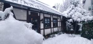 ein schneebedecktes Haus mit einem Gebäude in der Unterkunft Ferienhaus Färber in Bad Harzburg