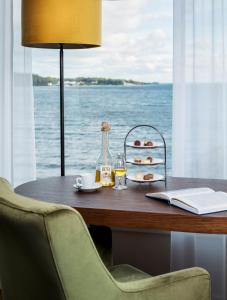 a table with a bottle of wine and a plate of food at Hotel Wassersleben in Flensburg