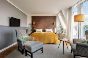 a bedroom with a bed with a yellow blanket at Hotel Wassersleben in Flensburg +24 photos