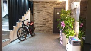 una bicicletta parcheggiata di fronte a un edificio con fiori di Hotel HueStay-KeumHo a Seogwipo