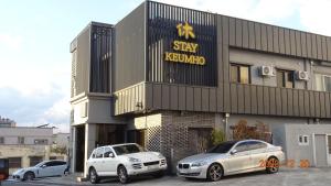 西归浦市Hotel HueStay-KeumHo的两辆汽车停在Astay kerkvo大楼前