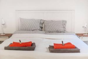 - un lit blanc avec 2 oreillers rouges dans l'établissement Little Corner at the Historic Jewish District with AC, à Budapest