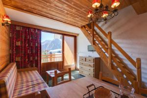 a living room with a staircase and a room with a table at Vacancéole - Résidence Meijotel in Les Deux Alpes