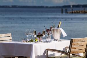 a table with glasses and a bottle of wine on the beach at Hotel Wassersleben in Flensburg
