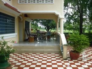 a screened in porch with a checkered floor at Meas Family Homestay in Angk Ta Saom