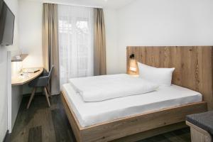 a bed in a room with a desk and a bed at Hotel-Gasthaus Engel Luttingen in Laufenburg