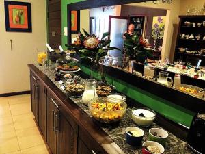 a buffet line with bowls of food on a counter at One On Hely in Mtunzini