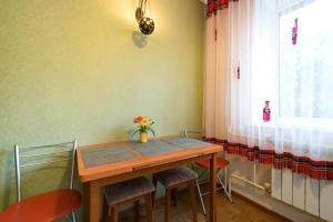 a dining room table with chairs and a window at Nadezhda Apartments on Gogolya 117 in Almaty