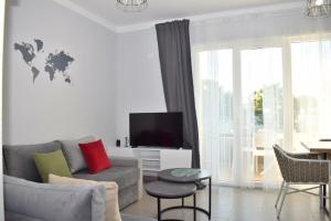 uma sala de estar com um sofá e uma televisão em Wide Beach Apartment - 236 em Durrës