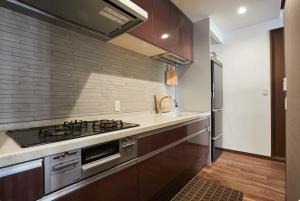 a kitchen with a stove and a sink at Kyodo Private House in Tokyo