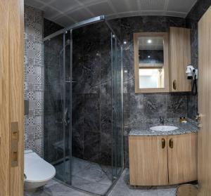 a bathroom with a shower with a toilet and a sink at Hotel Yesilpark in Istanbul