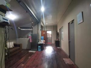 a living room with a couch and a hard wood floor at Ken's Inn in Coron