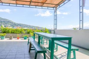 安汶的住宿－LeGreen Suite Waihaong，屋顶上的绿色野餐桌和长凳