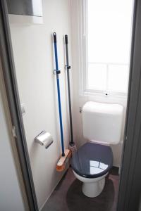 a bathroom with a toilet with two mop at Mobile Homes by KelAir at Camping Domaine des Ormes in Dol-de-Bretagne