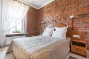 een slaapkamer met een bed met een bakstenen muur bij Hotel Gogol House in Sint-Petersburg