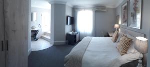 a bedroom with a large bed and a bathroom at Villa Tuscana in Port Elizabeth