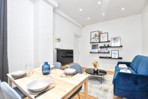 ein Wohnzimmer mit einem Tisch und einem blauen Sofa in der Unterkunft CMG Sentier - Cadet in Paris