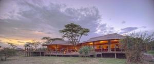 a house in the middle of a field at Saruni Leopard Hill in Naboisho