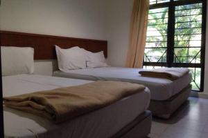 a bedroom with two beds and a window at Villa Mommy A Famosa Resort in Melaka