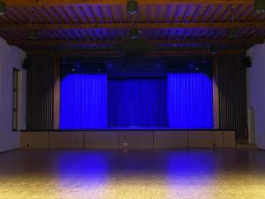 a large stage with blue lights in a room at Hotel Hirschen Hinwil in Hinwil